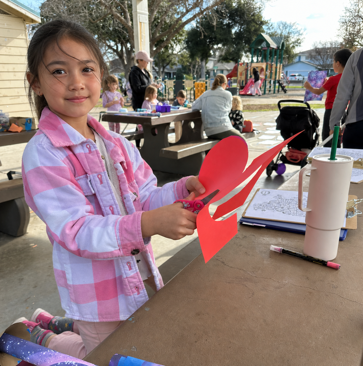 A child launching a handmade rocket across a chalk map